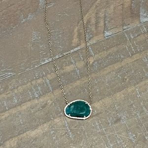 Yellow gold necklace with emerald and diamond pendant.